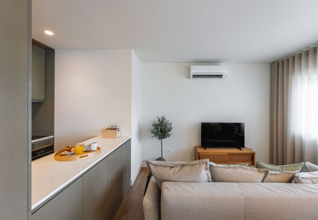 Salon moderne avec canapé, télévision connectée et accès à la terrasse
